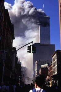 USA. New York City. September 11, 2001. Tower 1 of the World Trade Center burns as shocked New Yorkers loo