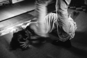 Man Kicking Woman on Floor