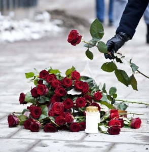 A man places a stalk of red rose on the location where late Swedish Prime Minister Olof Palme was shot and killed 25 years ago on a street in central Stockholm