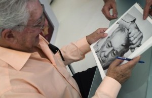 Peruvian writer Mario Vargas Llosa, winner of the 2010 Nobel Prize in Literature, looks at a portrait of himself at the Madrid Book Fair
