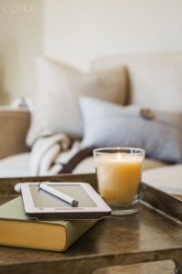 Tablet, book and glass of orange juice