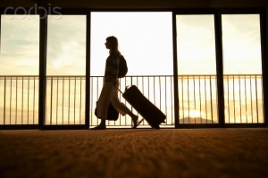 Woman walking through airport with wheeled suitcase