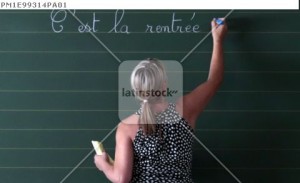A teacher writes a phrase on the blackboard of her classroom on the first day of the new school year at a primary school in Nice