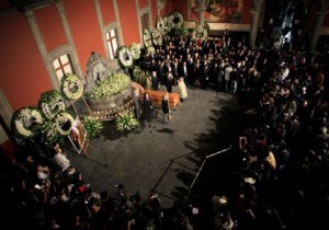 The body of Mexican literature writer Carlos Monsivais lies in a coffin as friends stand during his wake at Museo de la Ciudad in Mexico City