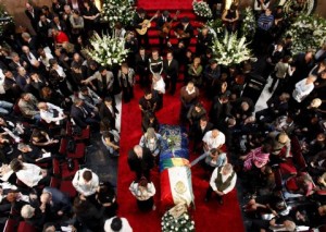 The body of Mexican writer Monsivais lies in a coffin as people mourn during his wake at Bellas Artes museum in Mexico City