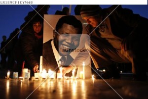 People place candles near a photo as they pay tribute to former South African President Nelson Mandela at the Trocadero square, in front of the Eiffel Tower in Paris