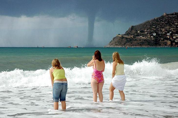 Tourists watch a whirlwind from the beach in Turkey's Mediterranean coastal city of Antalya. Photo by Anatolian
