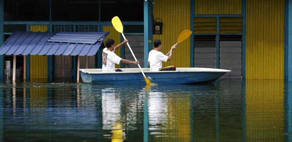 Volunteers monitor their flooded neighbourhood to keep it from being looted in the Malaysian village of Kampung Sungai Rambai. Photo by Bazuki Muhammad