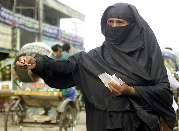 A Bangladeshi woman distributes advertisement handbills among rickshaw passengers and pedestrians in Dhaka September 9, 2003. She is one of many who take up such employments at a monthly salary of a meagre 1,500 taka ($26) per month in job scarce Bangladesh. REUTERS/Rafiqur Rahman NA/DL