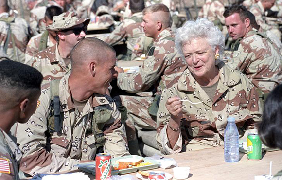 First Lady Barbara Bush talks with an army trooper as she and husband, President George H.W. Bush, eat a Thanksgiving Day lunch with the troops in eastern Saudi Arabia on November 22, 1990.   REUTERS/Rick Wilking ( SAUDI ARABIA - Tags: POLITICS CIVIL UNREST) BEST QUALITY AVAILABLE