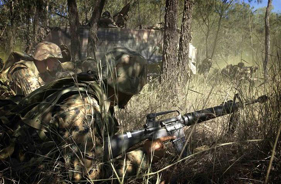 United States Marines participate in a military manouevers in the Australian bush of Shoalwater Bay training area near Rockhampton September 14, 2003. The soldiers were taking part in a joint U.S. and Australian military exercise called "Operation Crocodile 2003" where about 10,000 troops are implementing the planning and execution of an Australian-led and U.S.-supported combined operation. Picture taken September 14, 2003. EDITORIAL USE ONLY REUTERS/Australian Defence Force/Corporal Ashley Roach WB