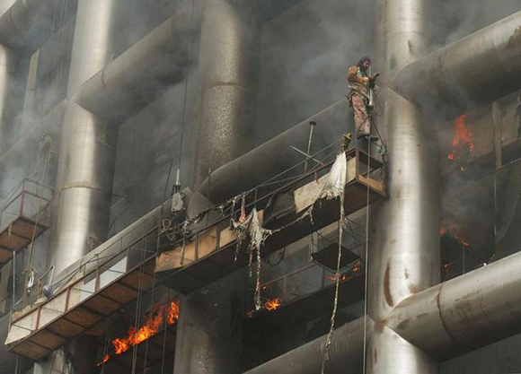 A worker caught in a building fire waits for rescue in an office under construction in Mexico City, October 22, 2003. Four workers died, and six were injured after sparks from their soldering started a major fire on a large advertising banner hanging on the building. The building's construction is one of several new office towers being built in the Santa Fe district of the capital. REUTERS/Sringer DA/HB