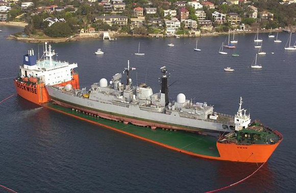 HMS Nottingham sits on the deck of the Swan, a heavy lift ship in Sydney Harbour October 22, 2002 to be prepared for shipping back to the United Kingdom. The operation to load the British destroyer onto the Swan is expected to take 12 hours when she will be towed to a nearby naval base and secured for the six week trip back to the United kingdom. The Nottingham ran aground on well chartered rocks at Lord Howe Island in July. REUTERS/HO/Jon Hamlet, Royal Navy FOR EDITORIAL USE ONLY MDB
