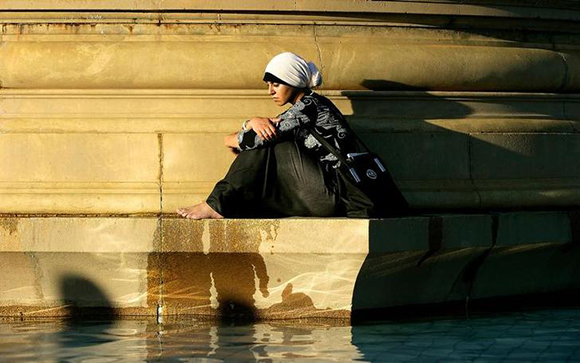 A Muslim woman mourns on a fountain during a vigil for London's bomb attack victims in Trafalgar Square in central London. Photo by Dylan Martinez