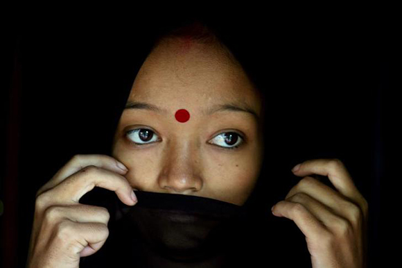 A HIV/AIDS patient stands in her hut in the northeastern Indian city of Siliguri. Photo by Rupak De Chowdhuri