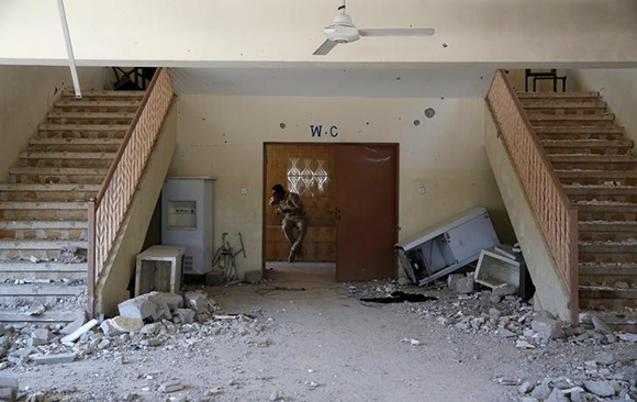 An Iraqi soldier washes his face in the toilet of an abandoned school at the frontline in al-Zanjili district in western Mosul, Iraq June 11, 2017. REUTERS/Erik De Castro TPX IMAGES OF THE DAY