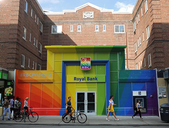 People pass a Royal Bank of Canada (RBC) branch adorned in colours of the Pride rainbow flag symbolizing gay rights, in downtown Toronto, Ontario, Canada June 13, 2017. Picture taken June 13, 2017. REUTERS/Chris Helgren