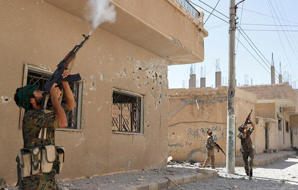 Kurdish fighters from the People's Protection Units (YPG) fires rifles at a drone operated by Islamic State militants in Raqqa, Syria June 16, 2017. REUTERS/Goran Tomasevic TPX IMAGES OF THE DAY