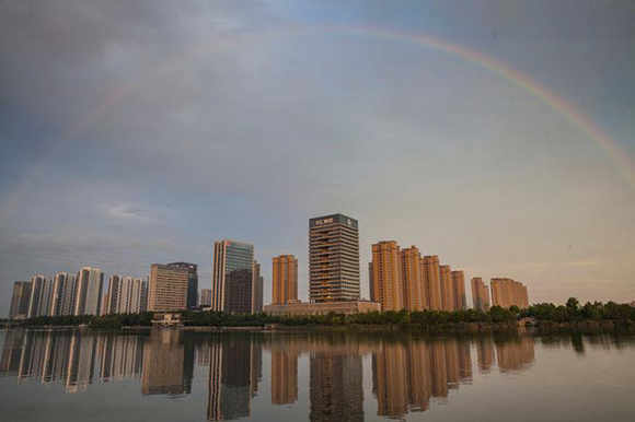 A rainbow appears over buildings reflected in water early morning in Shaoxing, China June 17, 2017. Picture taken June 17, 2017. REUTERS/Stringer ATTENTION EDITORS - THIS IMAGE WAS PROVIDED BY A THIRD PARTY. CHINA OUT. NO COMMERCIAL OR EDITORIAL SALES IN CHINA.
