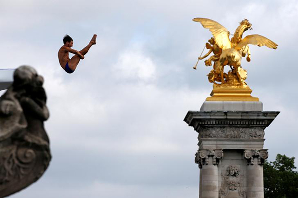A diver performs from the Pont Alexandre III bridge into the River Seine in Paris, France, June 23, 2017 as Paris transforms into a giant Olympic park to celebrate International Olympic Days with a variety of sporting events for the public across the city during two days as the city bids to host the 2024 Olympic and Paralympic Games. REUTERS/Jean-Paul Pelissier TPX IMAGES OF THE DAY