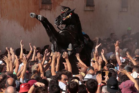A rider rears up on his horse while surrounded by a cheering crowd during the traditional Fiesta of Sant Joan (Saint John) in downtown Ciutadella, on the island of Menorca, Spain, June 23, 2017. REUTERS/Enrique Calvo