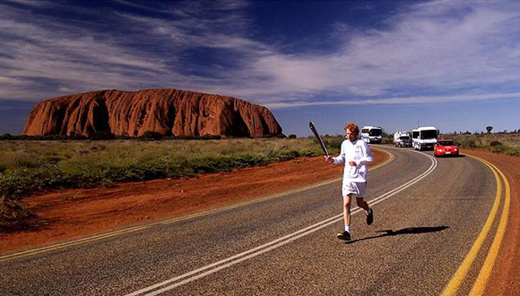 A local torchbearer runs pass Uluru, formerly called Ayers Rock, June 8. The Olympic torch is spending 100 days travelling around Australia on its way to Sydney  for the opening ceremony of the Sydney 2000 Olympic Games on September 15. (EDITORIAL USE ONLY)