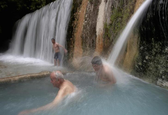  Visitors soak in a natural thermal spa as a man stands under a waterfall near the village of Aridea in Edessa, about 560 km (348 miles) northwest of Athens. Photo by John Kolesidis
