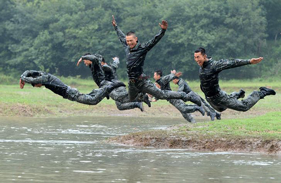 Soldiers jump into muddy water during a military training session at a mountain area in Heifei, Anhui province, China. Photo by Stringer