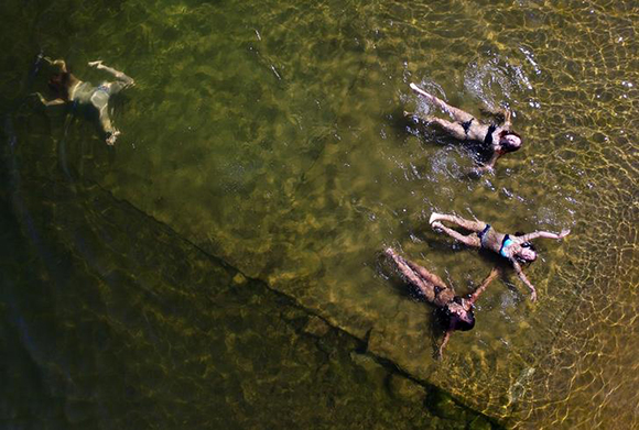 An aerial view shows women swimming in the Yenisei River on a hot summer day. Photo by Ilya Naymushin