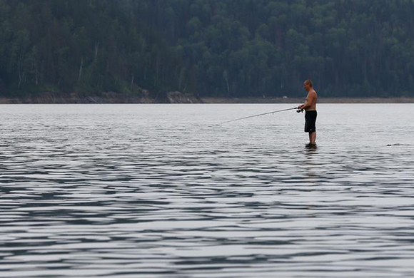 A man fishes while standing in the waters of the Yenisei River outside Krasnoyarsk, Russia. Photo by Ilya Naymushin