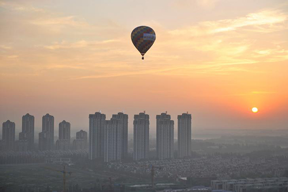  A hot air balloon flies over residential buildings in Wuqing District of Tianjin, China. Photo by Stringer