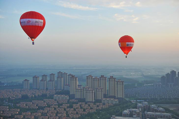 Hot air balloons fly over residential buildings in Wuqing District of Tianjin, China. Photo by Stringer