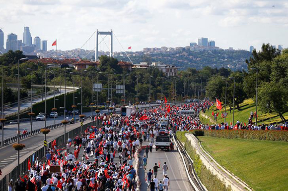  People walk to attend a ceremony marking the first anniversary of the attempted coup at the Bosphorus Bridge in Istanbul, Turkey July 15, 2017. Photo by Osman Orsal