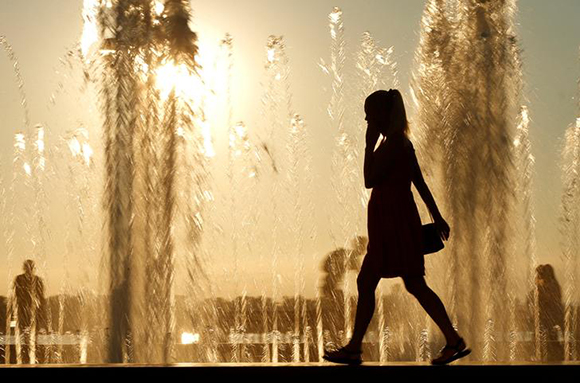  A woman is silhouetted in front of a fountain during sunset in Samara, Russia July 18, 2017. Photo by David Mdzinarishvili