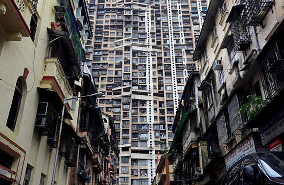  A high-rise residential tower is pictured behind old residential buildings in Mumbai, India July 24, 2017. Photo by Danish Siddiqui
