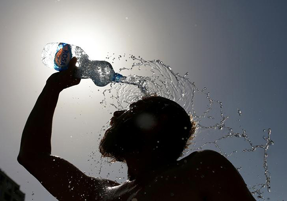  A man pours water on his face to cool off from hot weather in Skopje, Macedonia. Photo by Ognen Teofilovski 