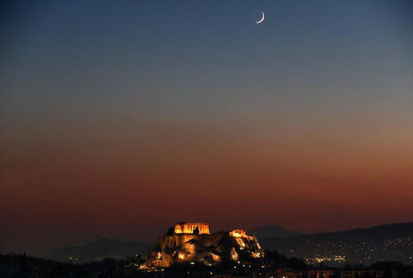  A waxing crescent moon rises over the lit Temple of Parthenon atop the ancient Acropolis hill in central Athens, Greece. Photo by Yannis Behrakis 