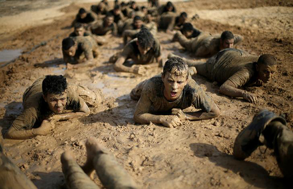  Young Palestinians crawl during a military-style exercise at a Hamas summer camp in Rafah in the southern Gaza Strip July 27, 2017. Photo by Ibraheem Abu Mustafa
