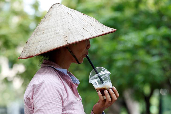 A fruit vendor drinks iced coffee in Hanoi, Vietnam Photo by Kham