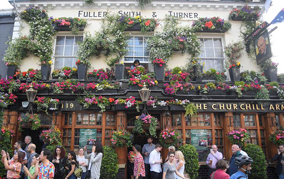Customers drink outside of The Churchill Arms pub in London, Britain Photo by Toby Melville