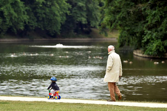 A man walks behind a boy in a park in Brussels, Belgium Photo by Eric Vidal