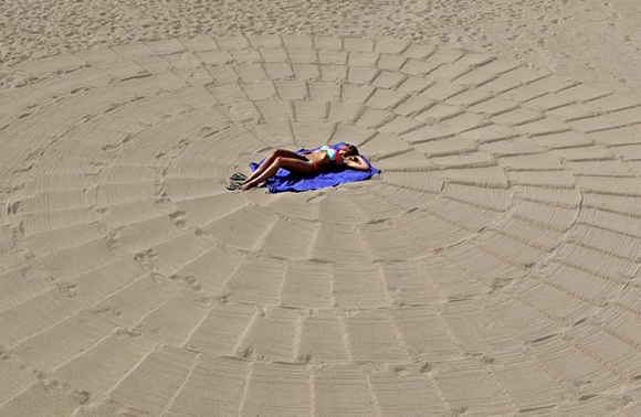 A woman enjoys the sun on a Croisette beach in Cannes, France Photo by Eric Gaillard