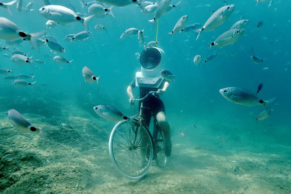 woman dives and pretends to ride a bike in Underwater Park in Pula, Croatia Photo by Antonio Bronic