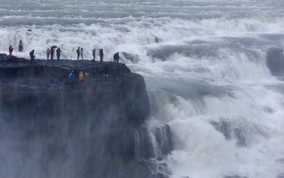 People watch the Gullfoss waterfall near Reykjavik, Iceland. Photo by Michaela Rehle