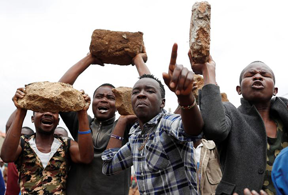 Supporters of opposition leader Raila Odinga hold up boulders in front of a barricade in Kawangware slum in Nairobi, Kenya, August 10, 2017. Photo by Goran Tomasevic