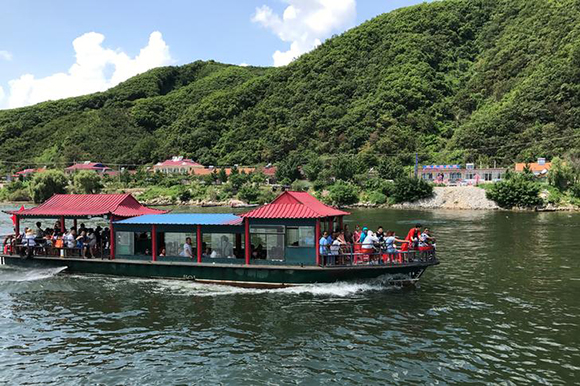 Chinese tourists are seen on a boat taking them from the Chinese side of the Yalu River for sightseeing close to the shores of North Korea, near Dandong, Liaoning province, China August 10, 2017. Photo by Philip Wen
