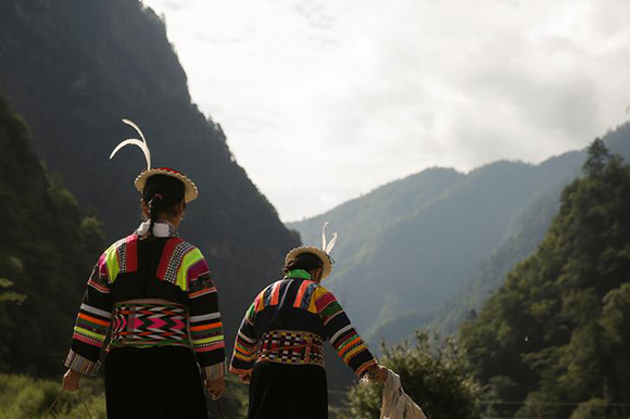 Women in traditional clothes walk in the Tibetan village of Gaoshinao in Jiuzhaigou county, south of the epicentre of Tuesday's earthquake, Sichuan province, China, August 11, 2017. Photo by Thomas Peter