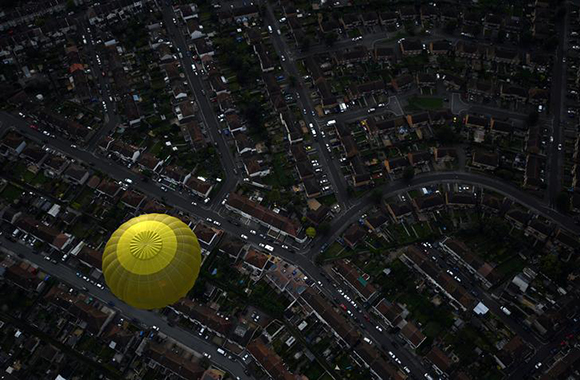 A balloon flies over rooftops in Bristol during the Bristol International Balloon Fiesta in southwest England, Britain August 11, 2017. Photo by Hannah McKay