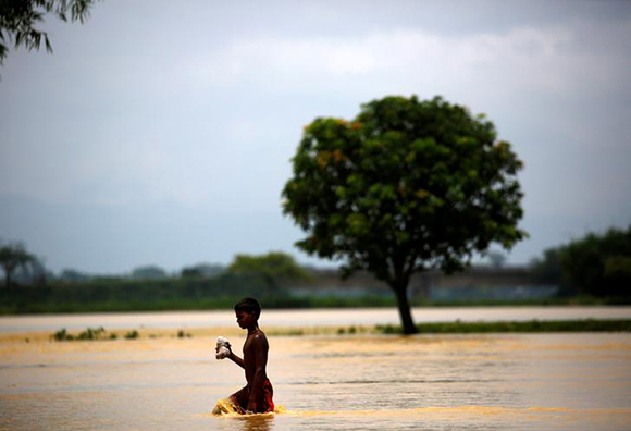 A boy walks along the flooded area in Saptari District, Nepal August 14, 2017. Photo by Navesh Chitrakar