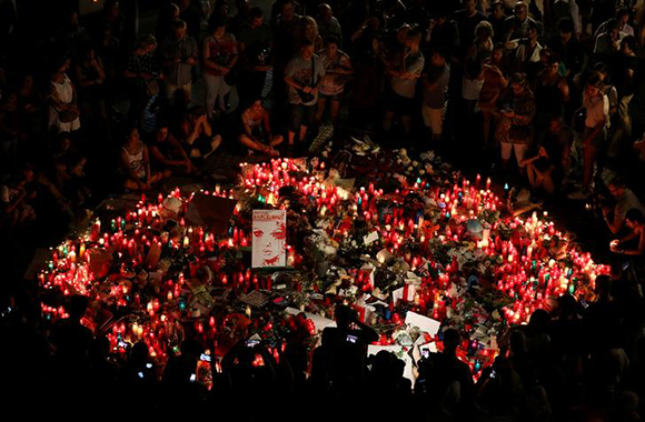People gather around an impromptu memorial a day after a van crashed into pedestrians at Las Ramblas in Barcelona, Spain August 18, 2017. Photo by Sergio Perez